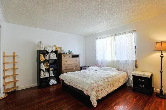 a bedroom with a bed and a wooden floor