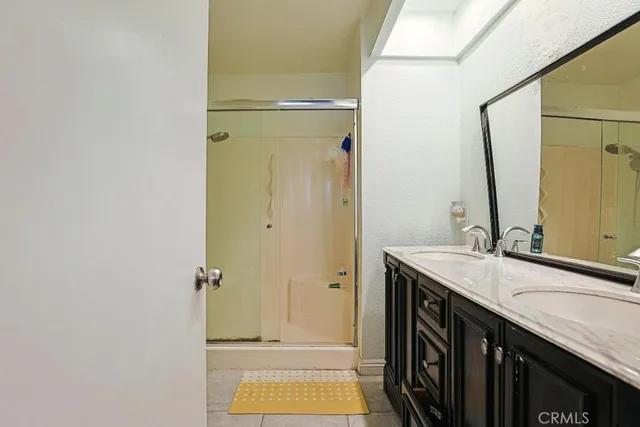 a bathroom with a granite countertop sink a mirror and a shower