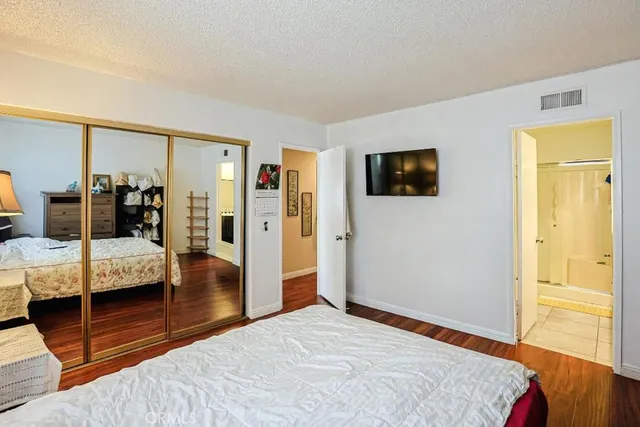 a bedroom with a bed and a flat tv screen