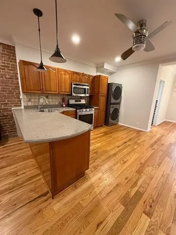 a view of a kitchen with kitchen island a counter top space and wooden floor