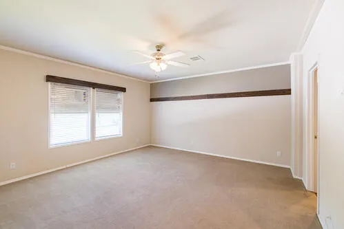 an empty room with a window and a ceiling fan