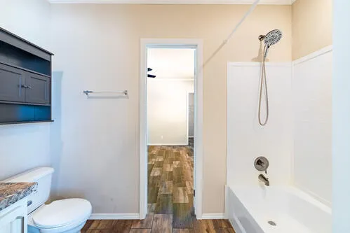 a spacious bathroom with a granite countertop sink a mirror and a bathtub
