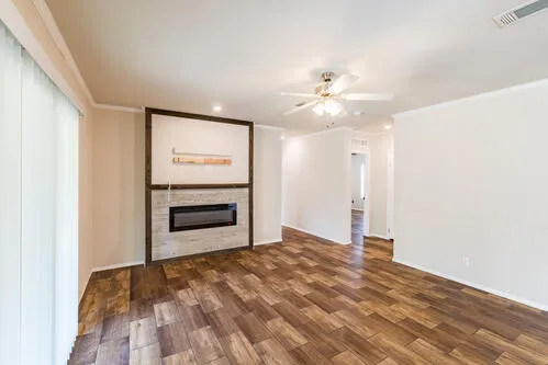 a spacious bedroom with a bed and a dresser with wooden floor