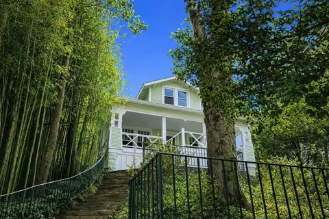 a view of a house with large windows and a small yard