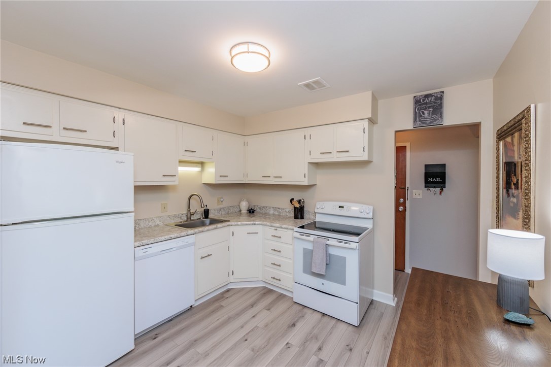 1750 Wagar Road, Unit 206 Rocky River, OH 44116 - Photo 16 of 33 Kitchen featuring white appliances, light countertops, light hardwood floors, and white cabinets