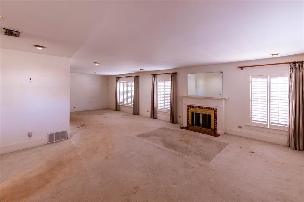 602 East Beauregard Street Rotan, TX 79546 - Photo 6 of 15 a view of an empty room with a fireplace and a window