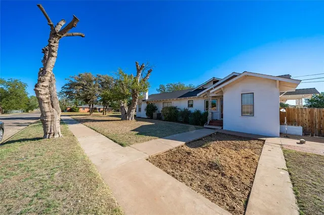 a view of a house with backyard and trees