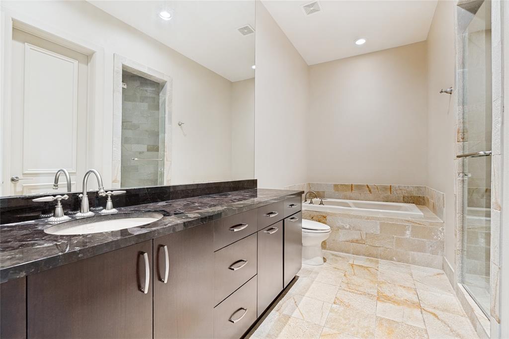 6432 Sudbury Road Plano, TX 75024 - Photo 33 of 38 a bathroom with a granite countertop sink a toilet a mirror and bathtub