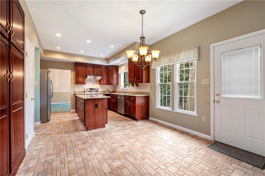 372 Indian Ridge Drive Coraopolis, PA 15108 - Photo 6 of 30 a kitchen with stainless steel appliances granite countertop a refrigerator a sink dishwasher a stove and a dining table with wooden floor