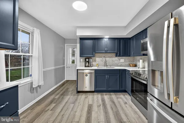 a kitchen with a refrigerator stove top oven and sink