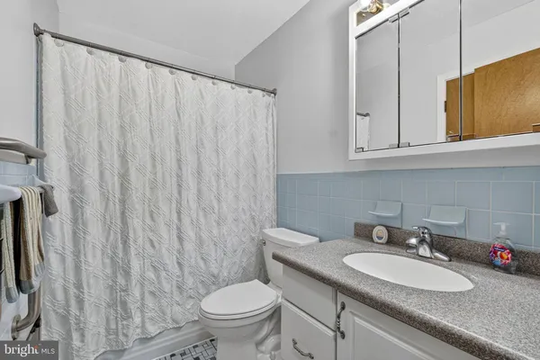 a bathroom with a sink a toilet and a mirror