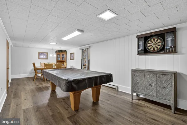 a living room with a table chairs and a wooden floor