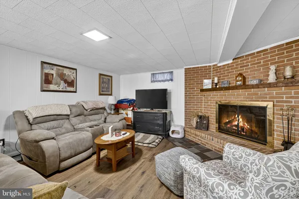 a living room with furniture a flat screen tv and a fireplace