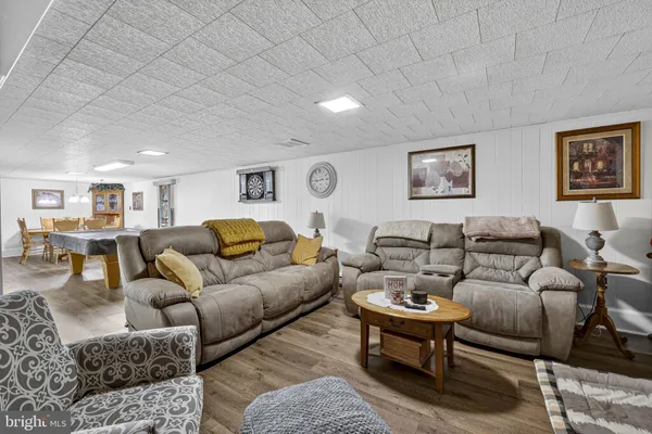 a living room with furniture a wall paintings and a lamp