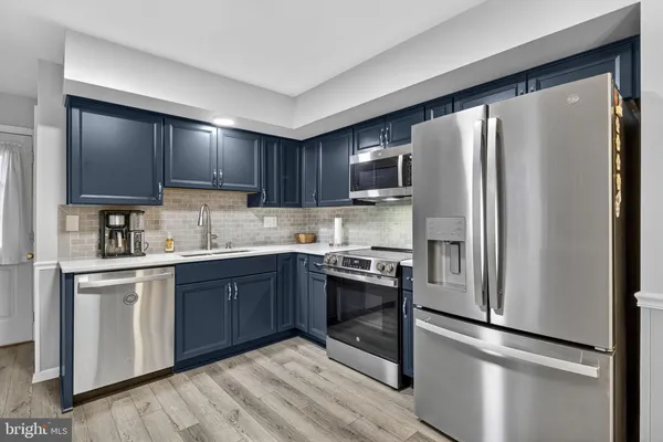 a kitchen with stainless steel appliances granite countertop a refrigerator stove and sink