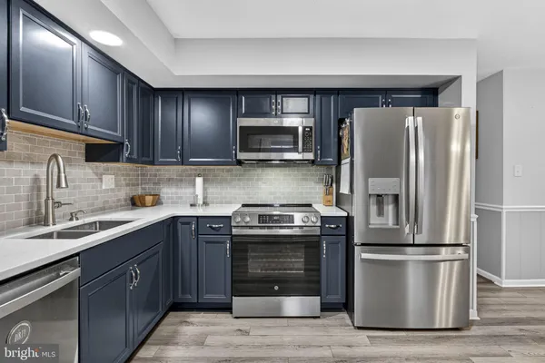 a kitchen with stainless steel appliances granite countertop a refrigerator stove and sink