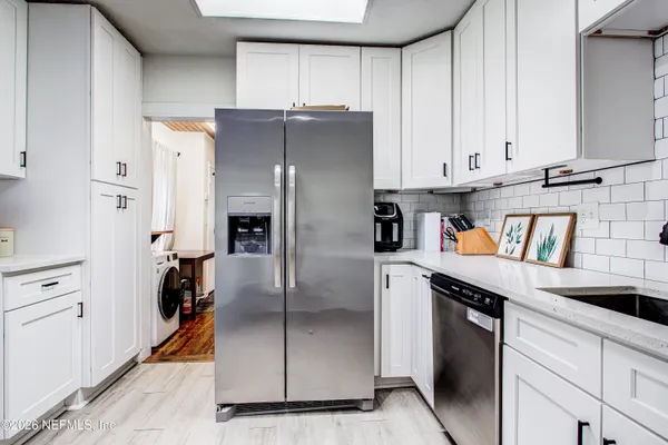 a kitchen with a refrigerator sink and cabinets