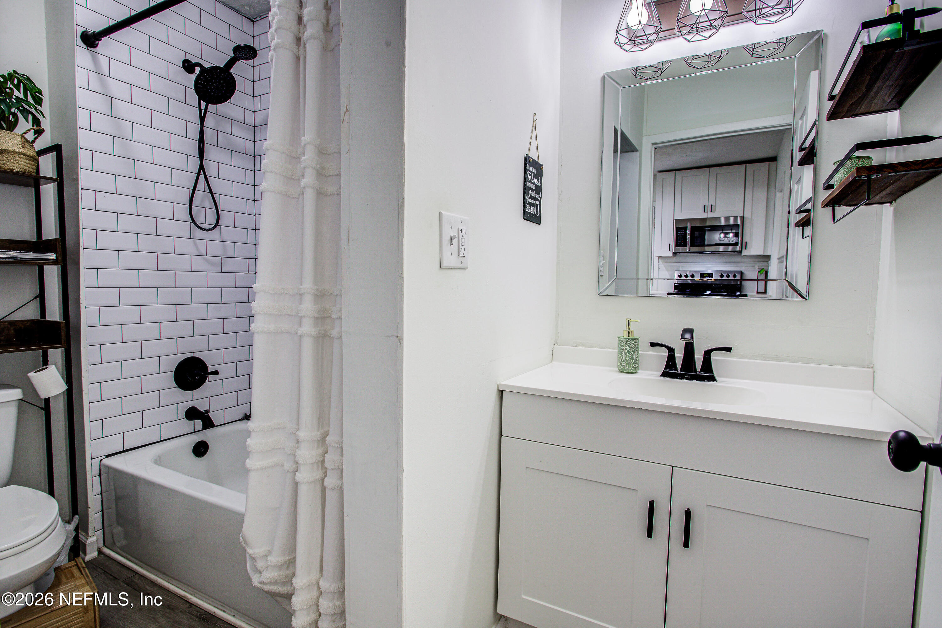 1441 Rensselaer Avenue Jacksonville, FL 32205 - Photo 22 of 33 a bathroom with a bathtub sink vanity mirror and toilet