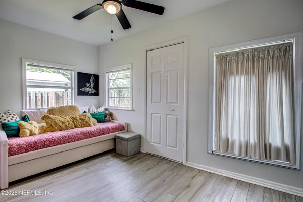 a spacious bedroom with a bed and flat screen tv