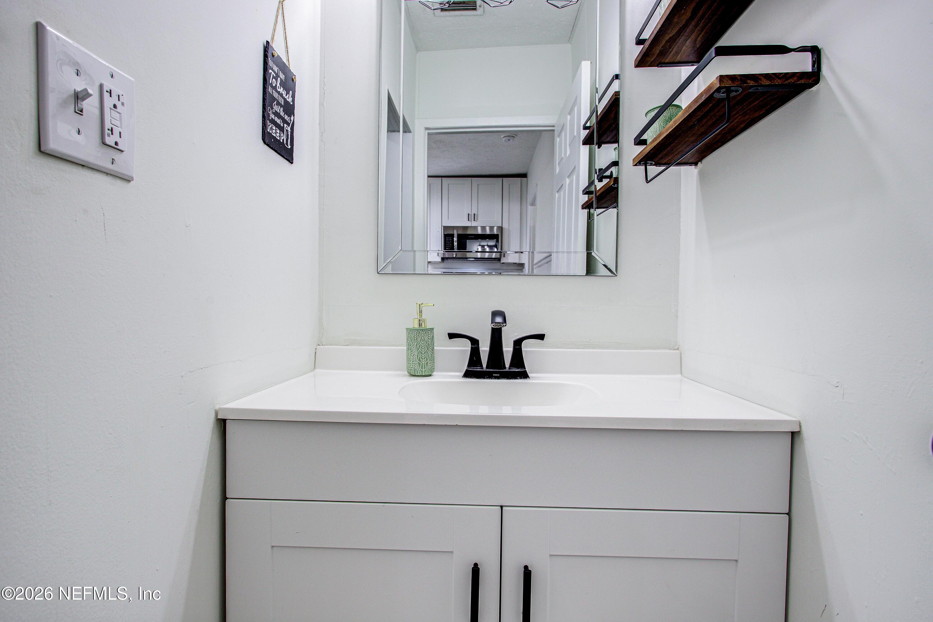 1441 Rensselaer Avenue Jacksonville, FL 32205 - Photo 27 of 33 a bathroom with a sink and a mirror