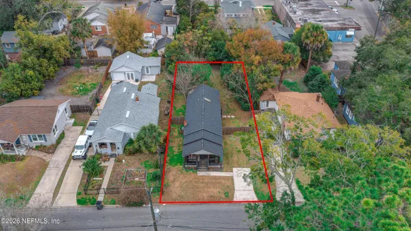 an aerial view of residential houses with outdoor space and trees