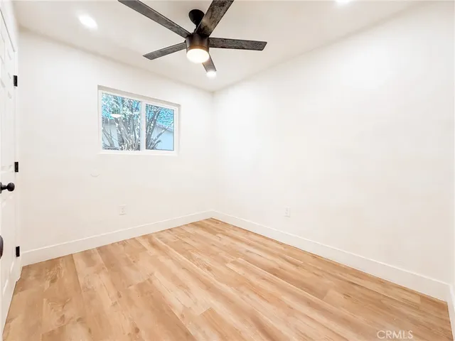 an empty room with a window and a ceiling fan