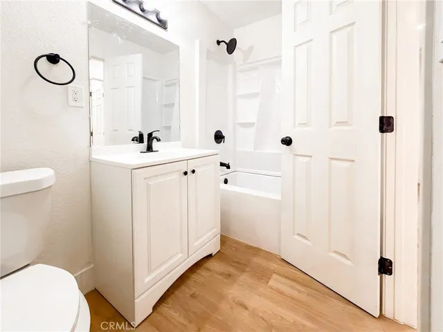 a bathroom with a sink a toilet a mirror a vanity and shower