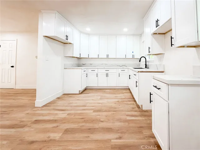 a kitchen with granite countertop white cabinets and white appliances