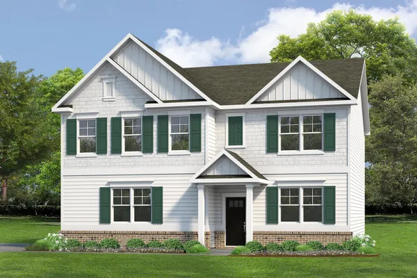 a front view of a house with a garden and yard