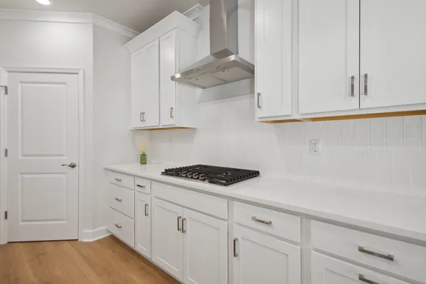 a kitchen with white cabinets and a stove