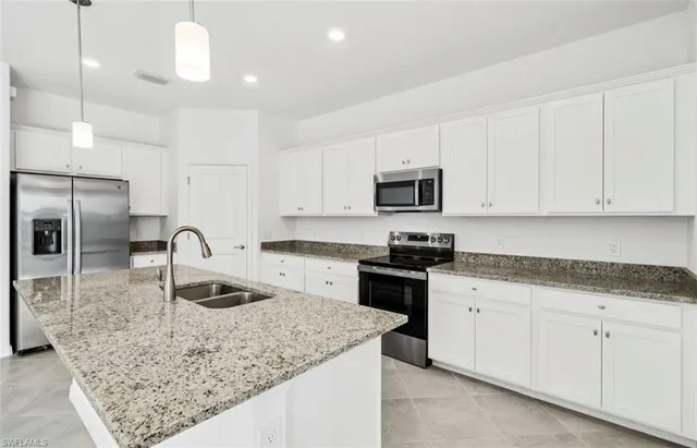 a kitchen with granite countertop a sink a stove and cabinets