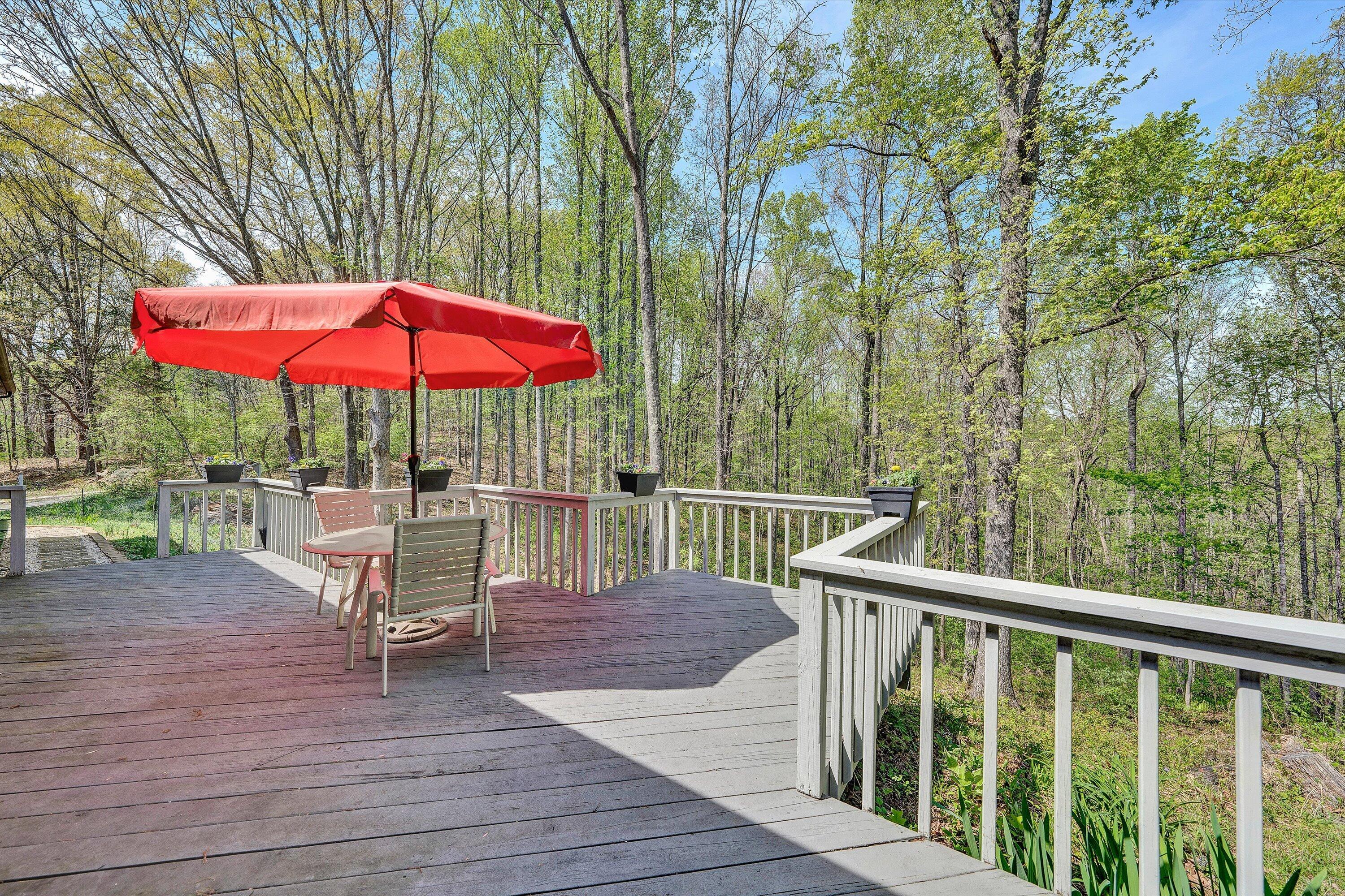 1124 Old Hollow Road Buchanan, VA 24066 - Photo 39 of 73 a view of a patio with a table and chairs under an umbrella with wooden fence