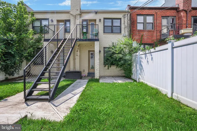 a view of a brick building next to a yard