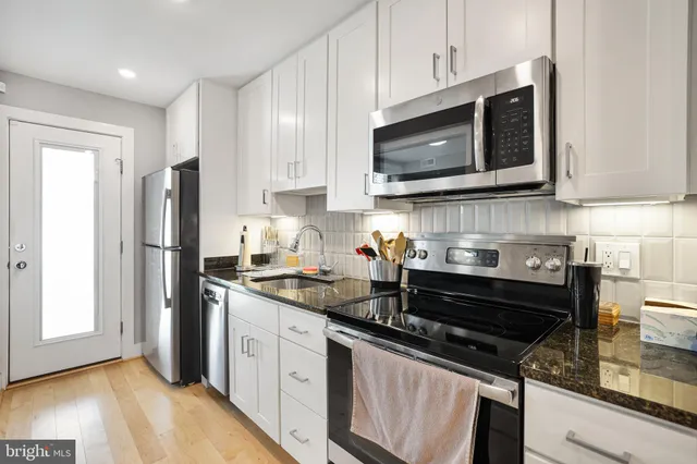 a kitchen with stainless steel appliances a stove microwave and sink