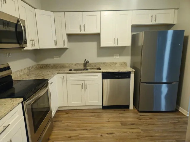 a kitchen with a sink a refrigerator and cabinets
