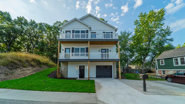 a front view of a house with a garden and yard