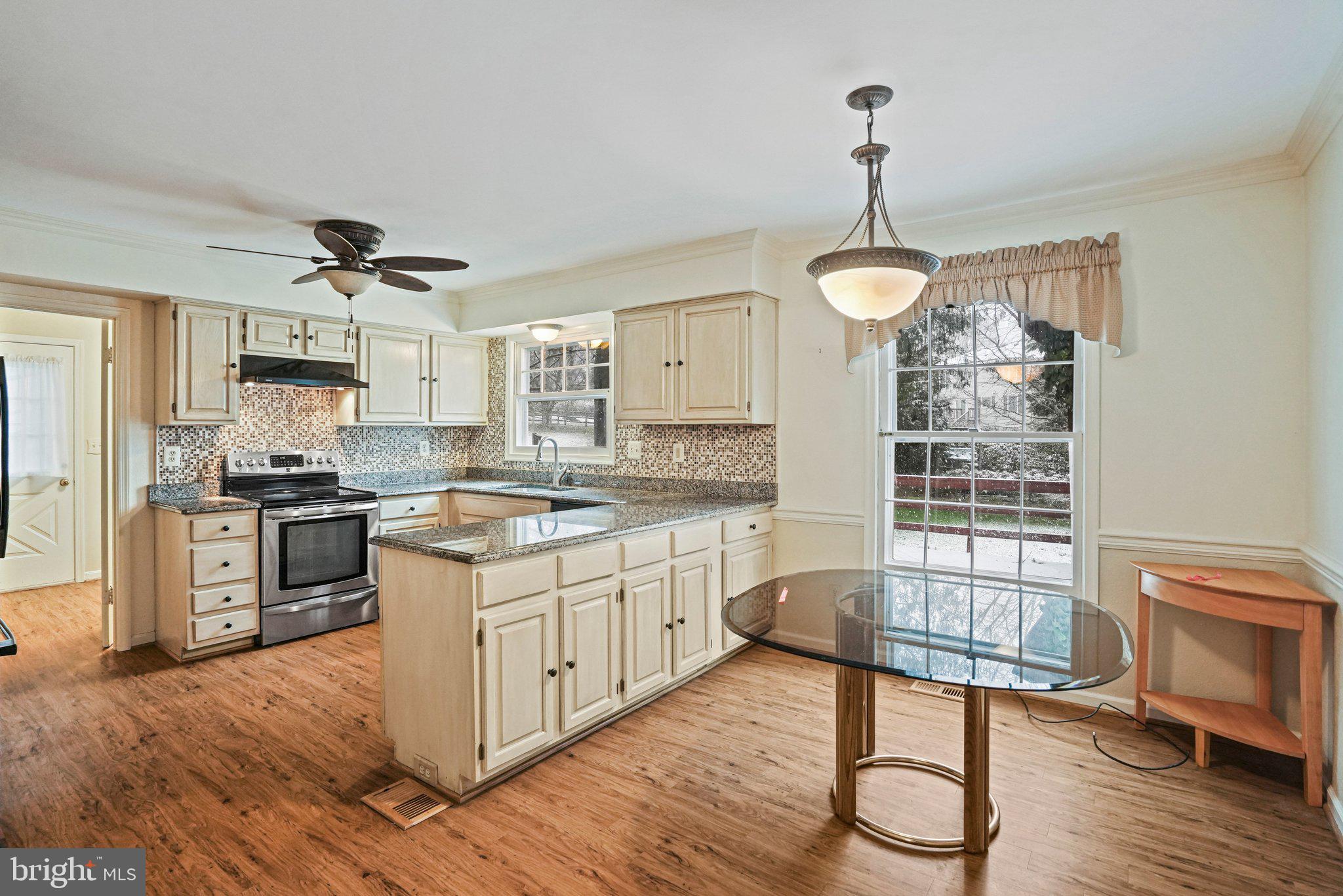 12737 Triple Crown Road Gaithersburg, MD 20878 - Photo 14 of 61 a kitchen with a refrigerator a stove cabinets and a dining table