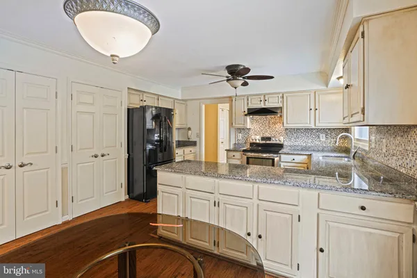 a kitchen with granite countertop a stove sink and cabinets