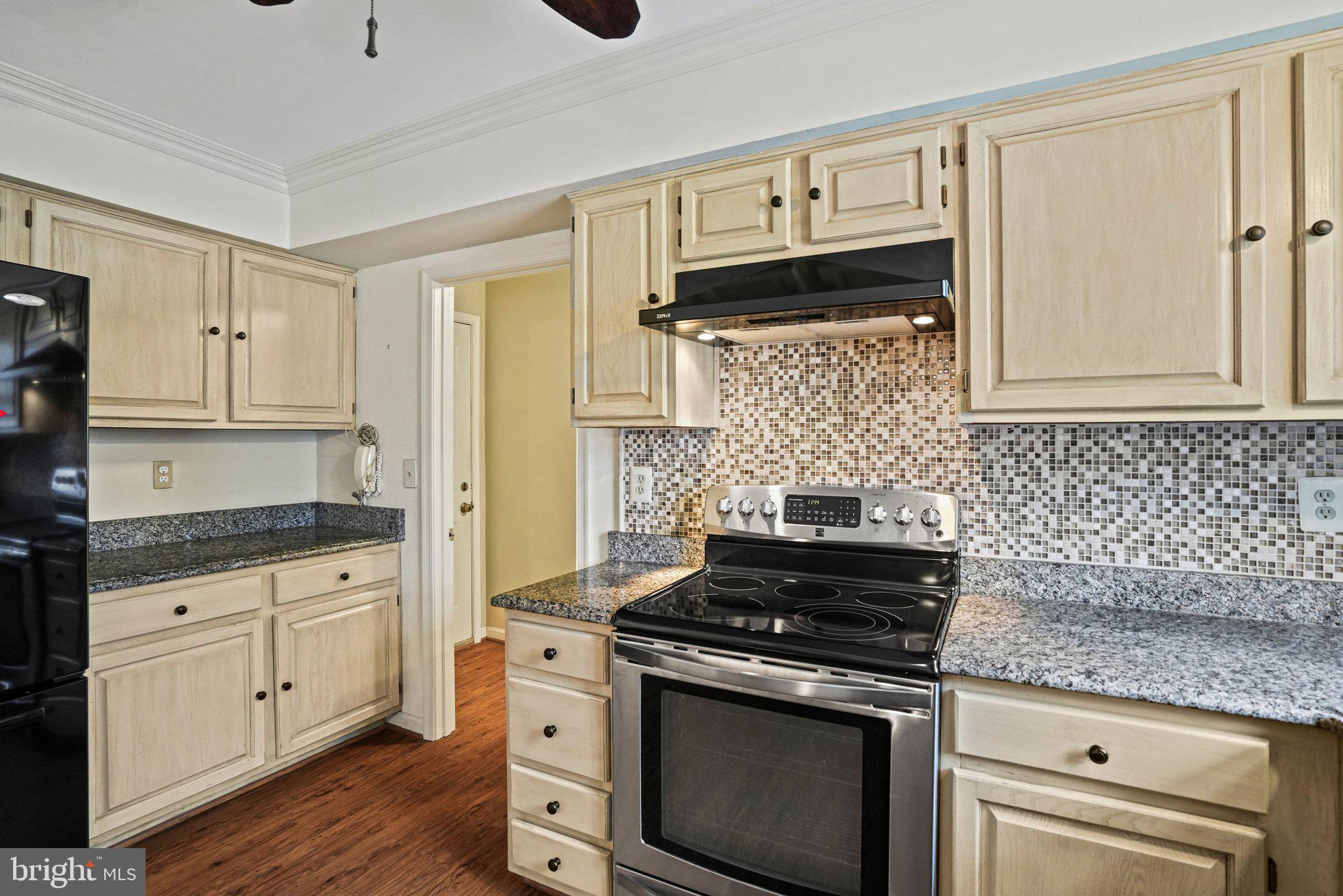 12737 Triple Crown Road Gaithersburg, MD 20878 - Photo 18 of 61 a kitchen with granite countertop a stove sink and cabinets
