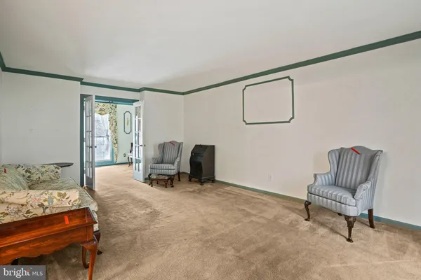 a view of an empty room with furniture and a window