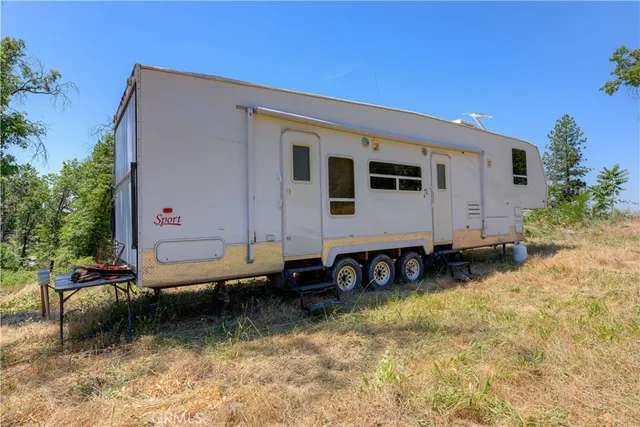 a backyard of a house with barbeque oven table and chairs