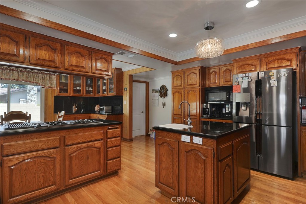 2441 Terraza Place Fullerton, CA 92835 - Photo 18 of 61 a kitchen with kitchen island granite countertop a sink cabinets and stainless steel appliances