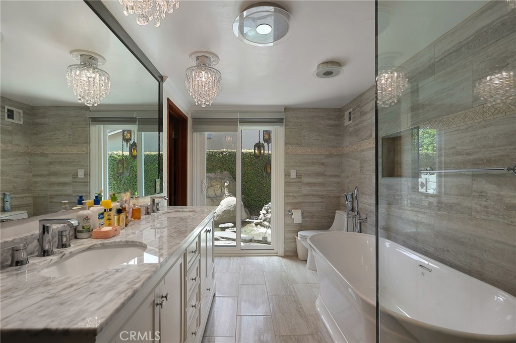 2441 Terraza Place Fullerton, CA 92835 - Photo 34 of 61 a large spacious bathroom with a granite countertop tub a mirror and a large window