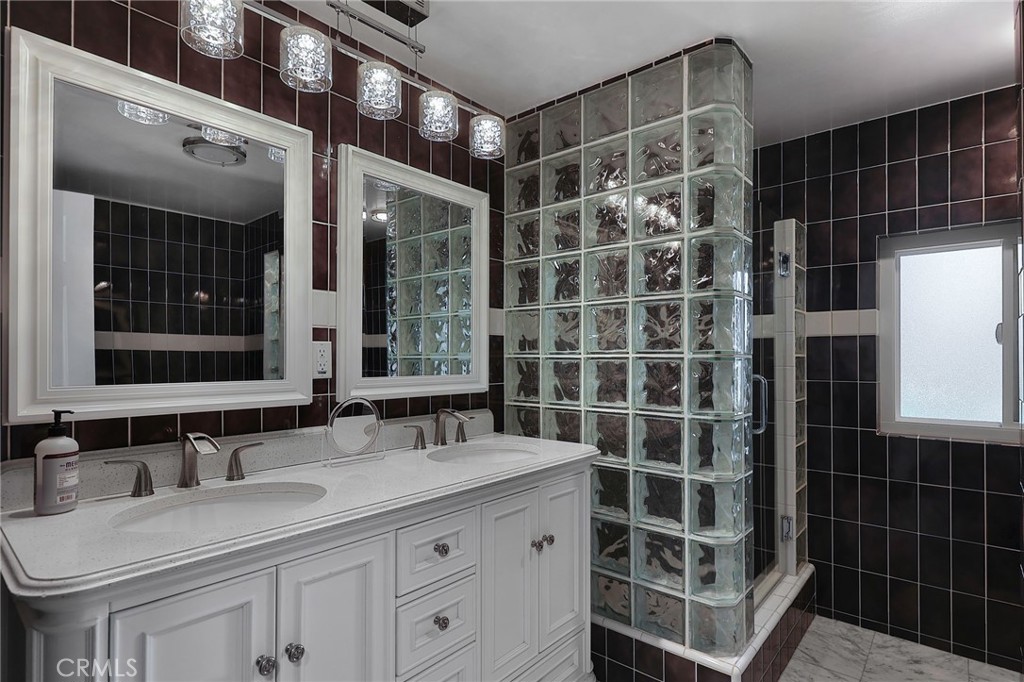 2441 Terraza Place Fullerton, CA 92835 - Photo 37 of 61 a bathroom with a double vanity sink a mirror and a shower