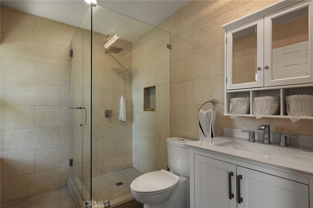 2441 Terraza Place Fullerton, CA 92835 - Photo 41 of 61 a bathroom with a granite countertop sink a toilet a shower and a mirror