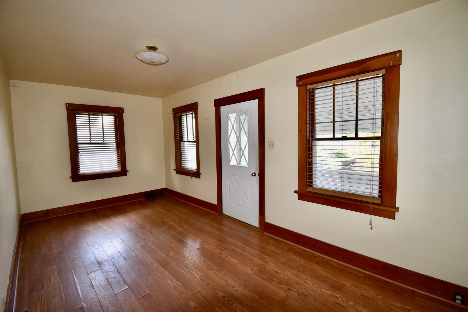 116 North Maple Street Clinton, IL 61727 - Photo 5 of 14 a view of an empty room with wooden floor and a window