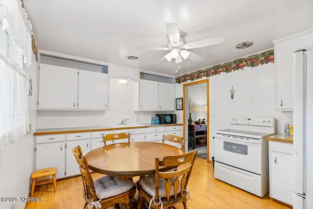 a kitchen with stainless steel appliances a stove a chandelier and white cabinets