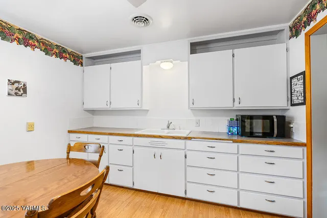 a kitchen with granite countertop white cabinets and white appliances