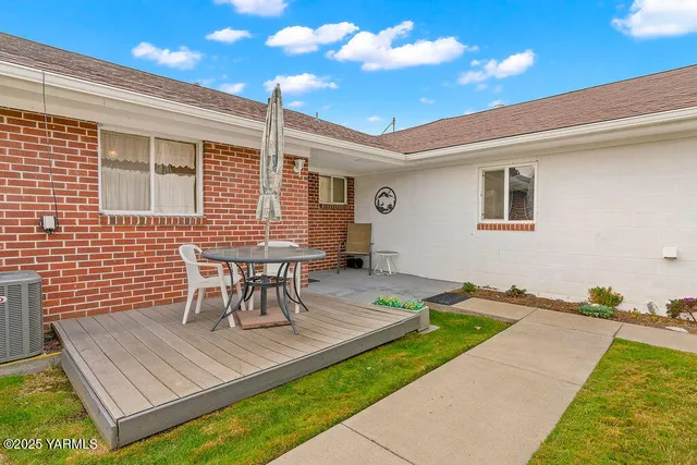 a view of a patio with table and chairs with wooden floor and fence