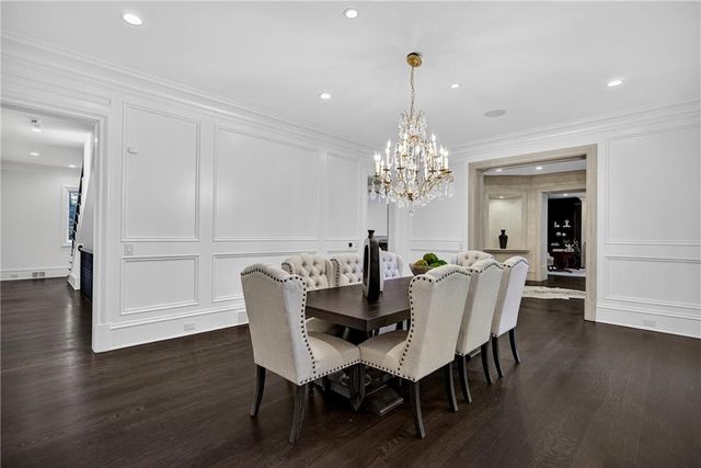 a view of a dining room with furniture a chandelier and wooden floor